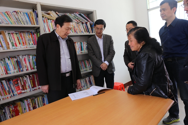 新建的村级活动中心的图书室里，刘国繁等仔细查看村民的借阅记录_副本.jpg